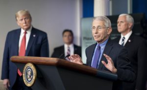 Anthony Fauci speaking at a White House briefing while President Trump listens.