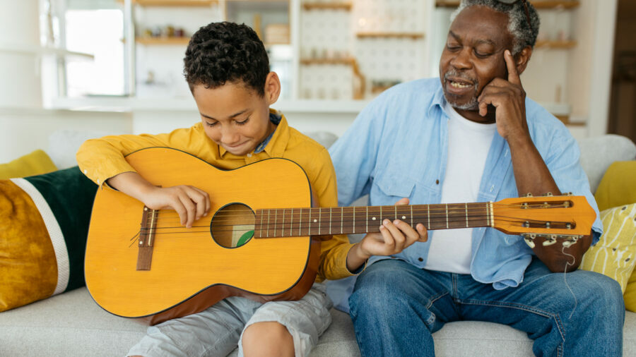 older-man-teaching-boy-guitar-e1665427624369.jpg